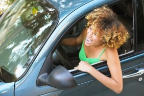 man clings hood speeding car